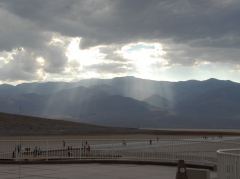 Sonnenlicht bricht durch Gewitterwolken in Badwater, Death Valley