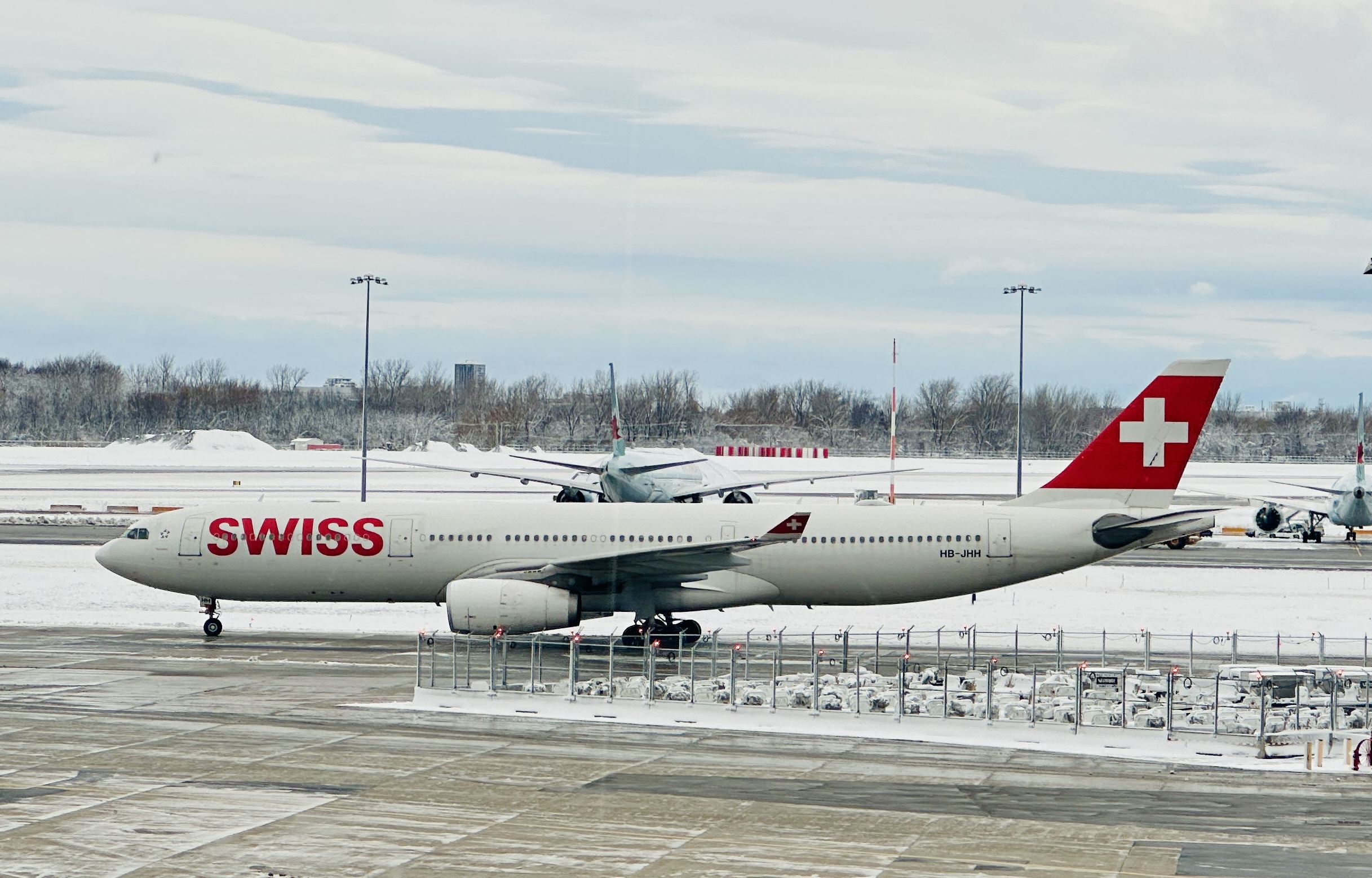 Der Airbus A330-300 der Swiss vor der verschneiten Landschaft am Flughafen Montréal