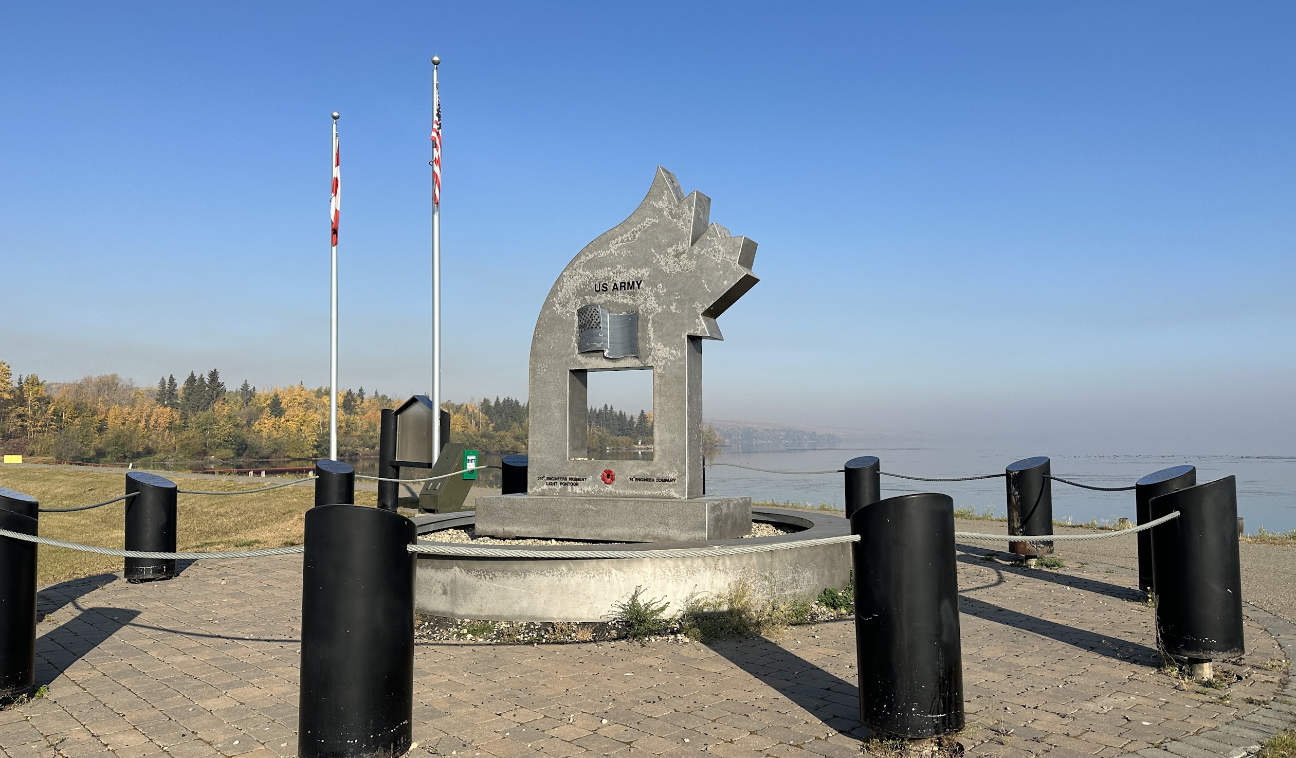 Das Monument mit Flaggenpolen von Kanada und der USA. Rund um das Monument sind Stelen mit eingravierten Namen der Verunfallten