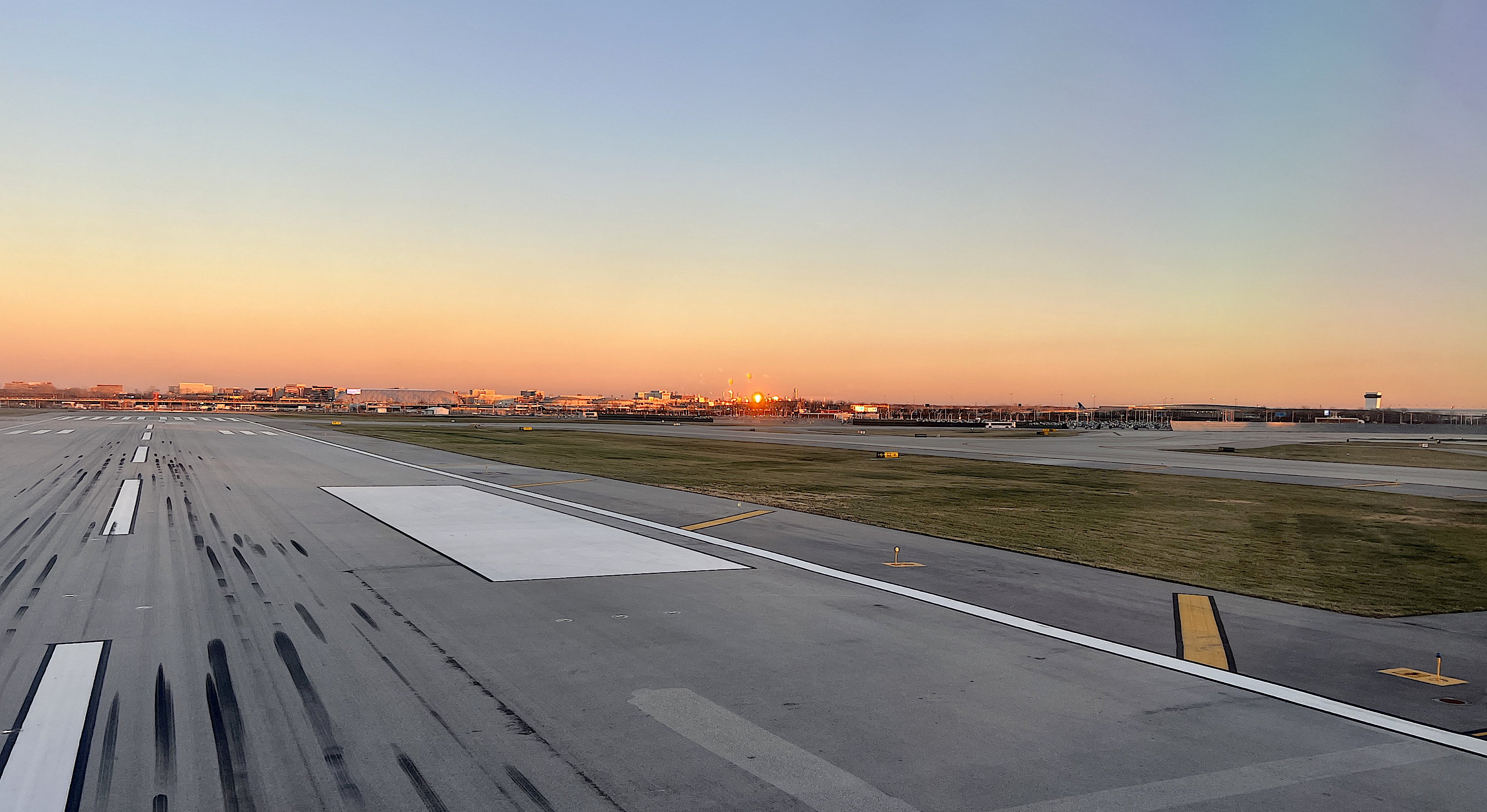 Die Runway des O'Hare, dahinter sieht man die Flughafengebäude im Licht des Sonnenuntergangs