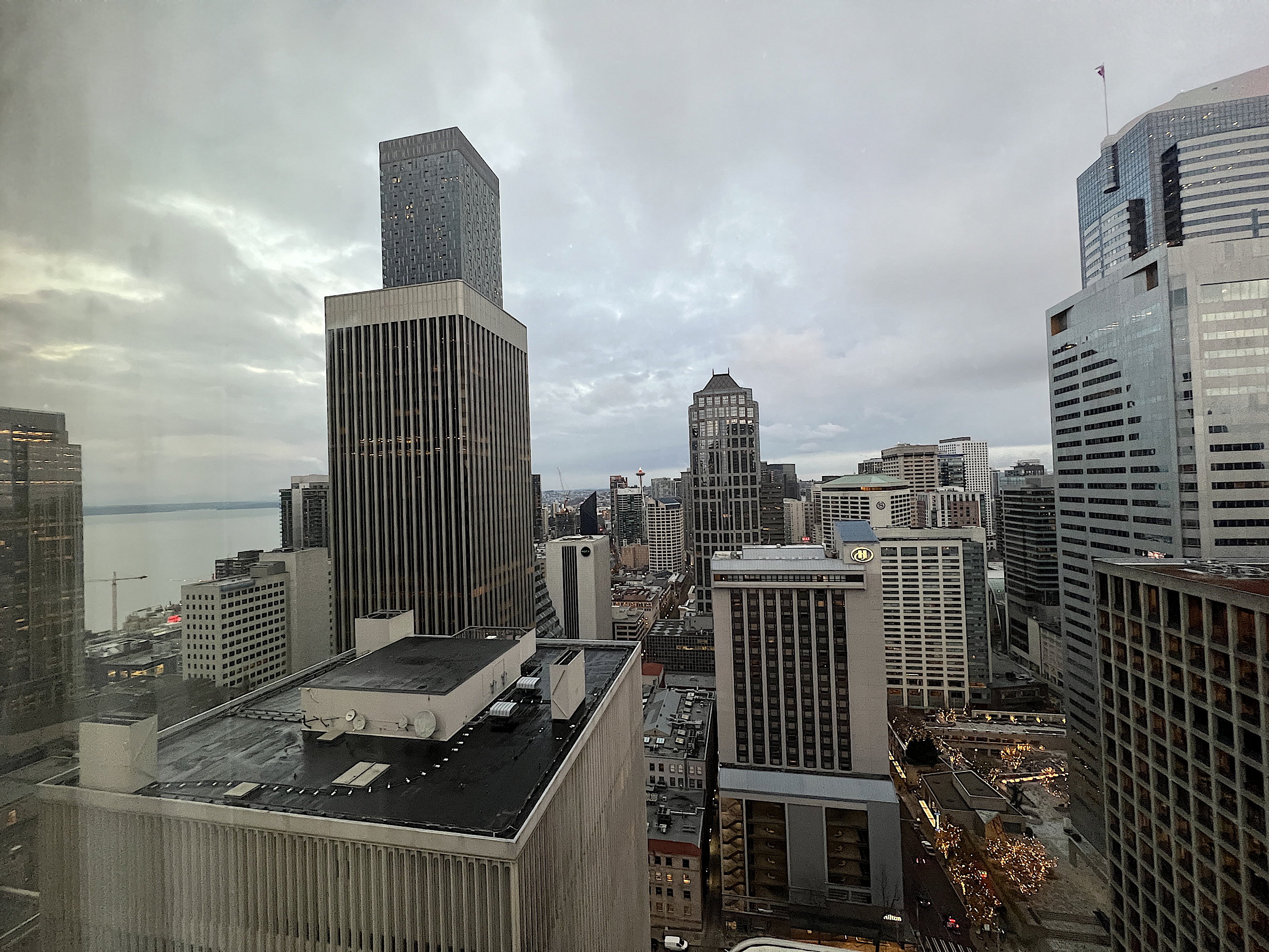 Ein letzter Blick aus dem grossen Hotelzimmerfenster auf die Stadt bei grauem Himmel