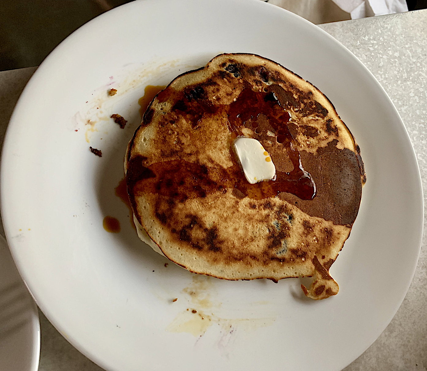 Blueberry-Pancakes mit ein wenig ungesalzener Butter und einem Klecks Birkensirup