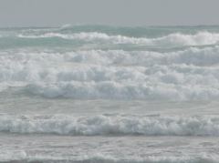 Wellen rollen ununterbrochen an den Strand der kühlen, windigen Ninety Miles Beach