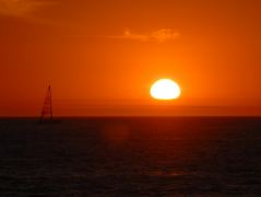 Die Sonne geht hinter der Nebelbank unter am Dockweiler Beach