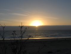 Die Sonne sinkt hinter die Wolkenwand über dem Meer