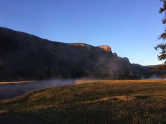 Erste Sonnenstrahlen über dem nebelverhangenen Madison River im Yellowstone Nationalpark