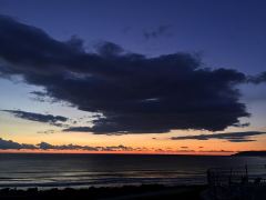 Dunkle Wolken über den letzten Sonnenstrahlen am Pazifik in Pismo Beach