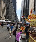 Blick über die sechste Avenue in Manhatten mit den bunten Ständen des Strassenfests