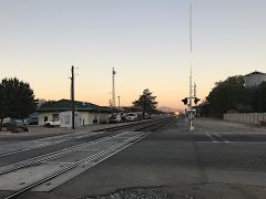 Die Lichter der Lok des von Osten herannahenden Güterzuges im Abendlicht