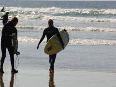 Surfer unterwegs ins Wasser